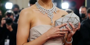 Celebrity in sculptural jewelry and geometric clutch at Golden Globes 2026